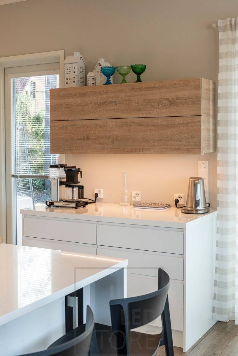 Profilé LED monté sur le fond d'une armoire pour éclairer le plan de travail. Ledstore.fi