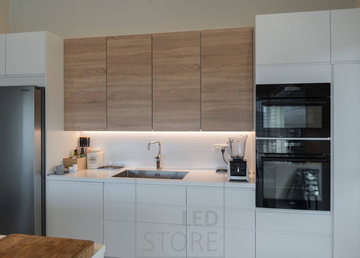 L'espace entre les meubles hauts de la cuisine est éclairé par une bande de LED. Ledstore.fi