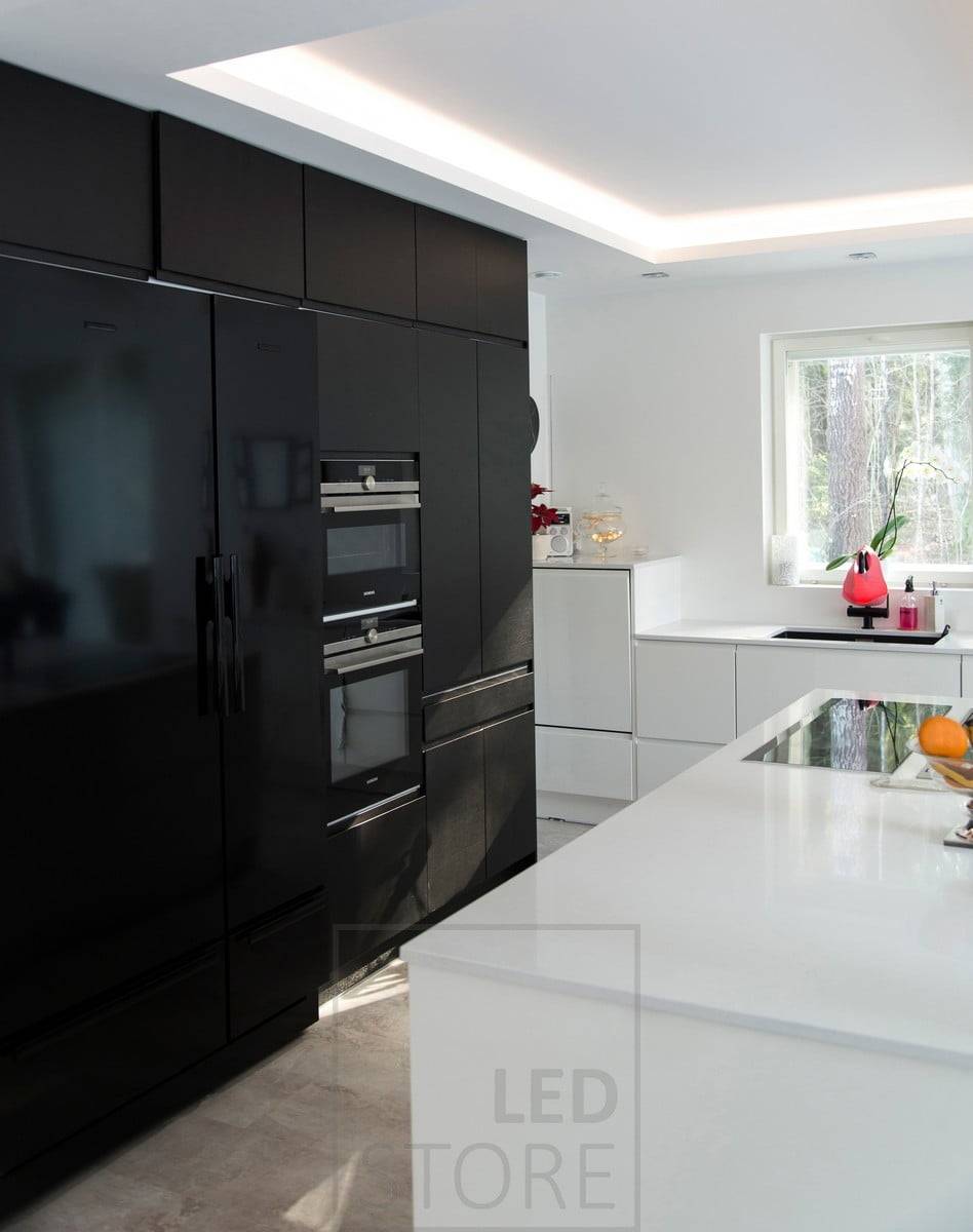 Dans la cuisine, un plafond lumineux, une bande de leds créant une lumière indirecte à partir d'une étagère spécialement créée. Ledstore.fi