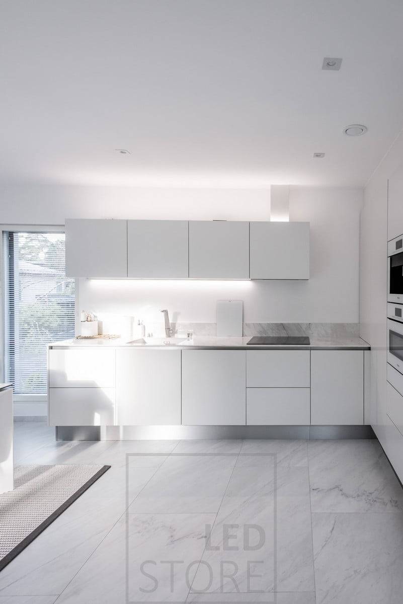 Dans la cuisine, un profilé LED monté sur le bas d'une armoire et un autre profilé LED fournissant une lumière indirecte sur le dessus des armoires. Ledstore.fi