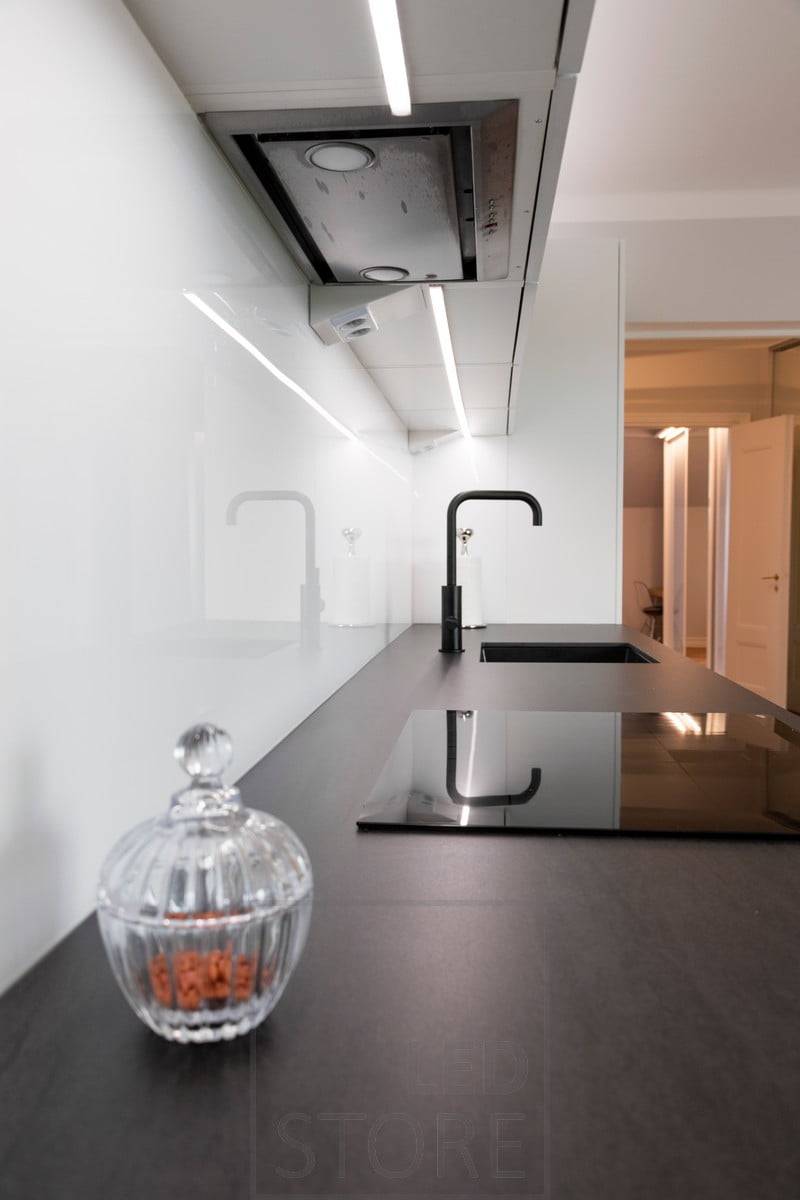Au milieu des armoires supérieures, une bande LED de faible hauteur éclaire le plan de travail de la cuisine. Ledstore.fi