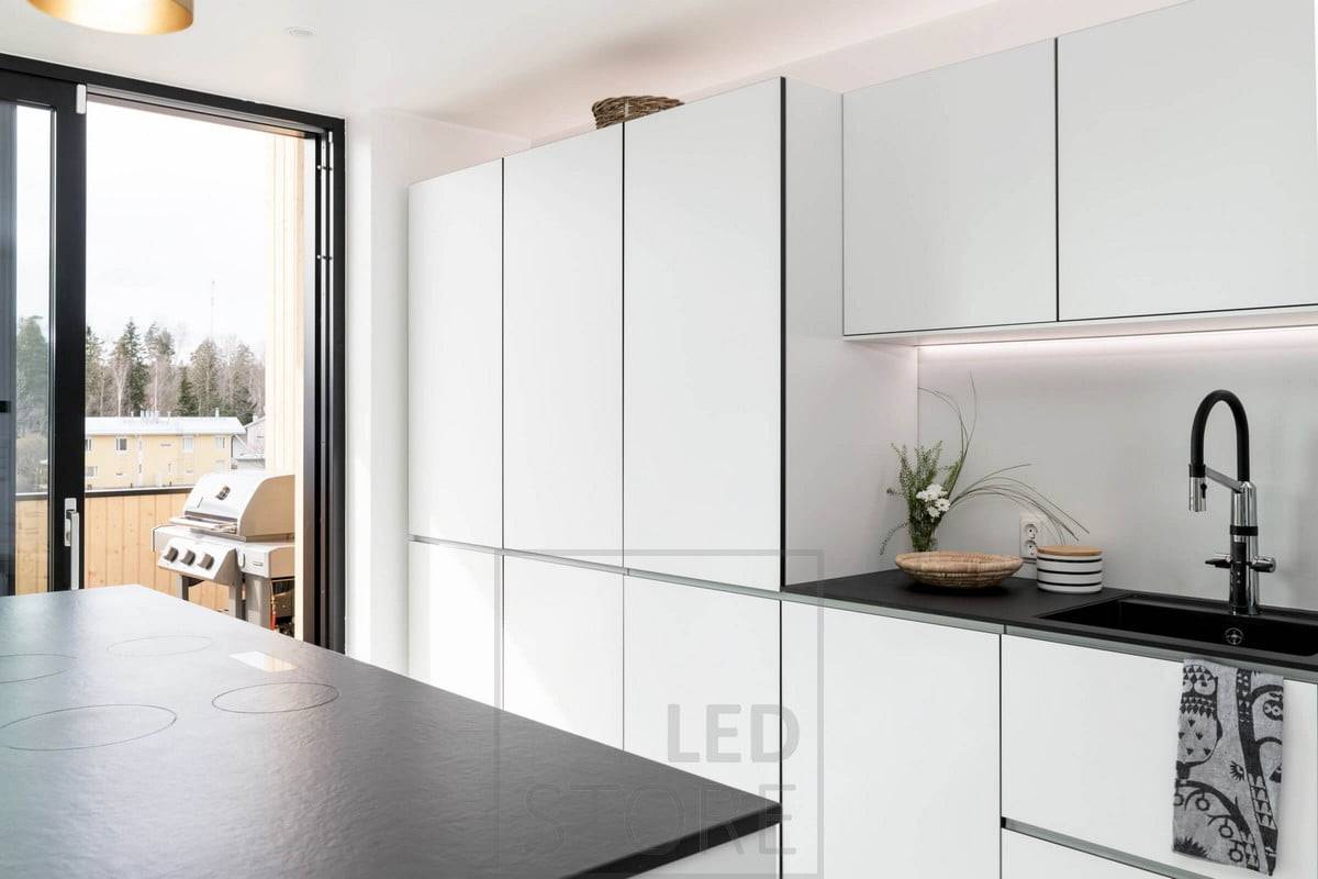 Dans la cuisine, éclairage plat sous les armoires supérieures près du mur. Eclairage d'ambiance indirect au-dessus des meubles. Ledstore.fi
