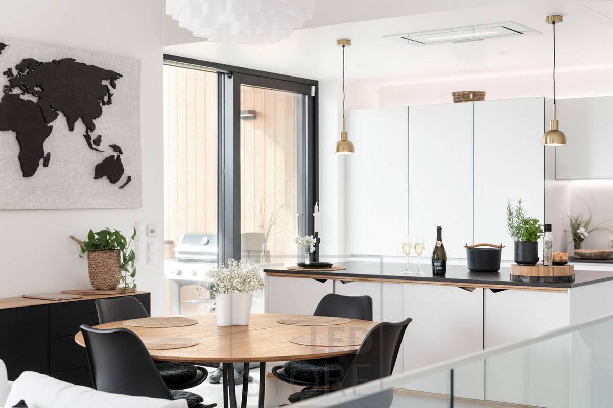 Dans la cuisine, des bandes LED sur le bas et le haut des armoires supérieures éclairent et soutiennent la lumière provenant des lampes intérieures. Ledstore.fi