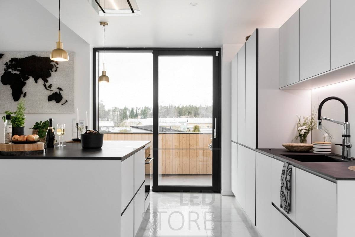 Dans la cuisine, le bas des armoires supérieures et le haut des armoires sont éclairés par des bandes LED. Ledstore.fi