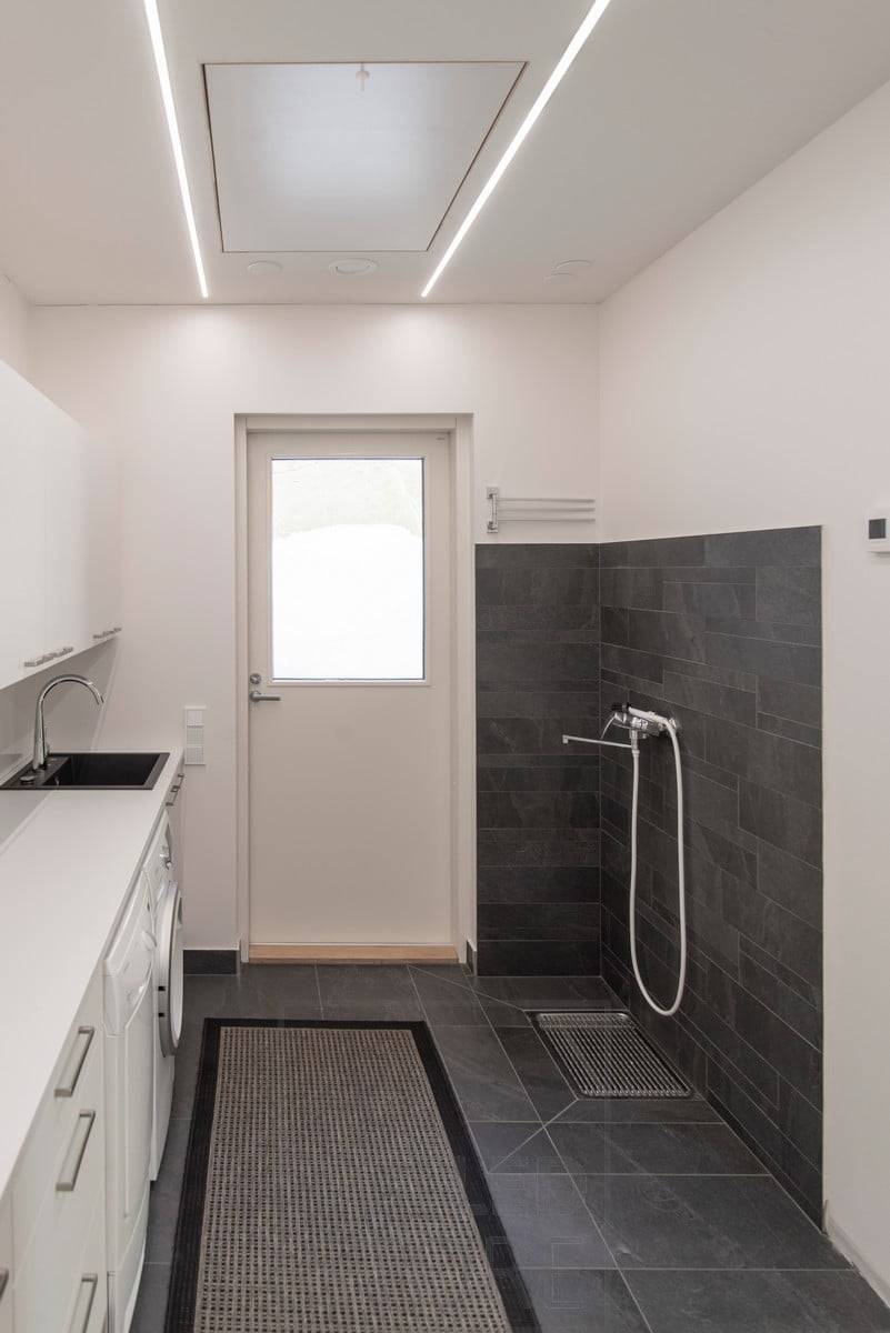 Des bandes LED dans les profilés muraux éclairent la buanderie. Ledstore.fi