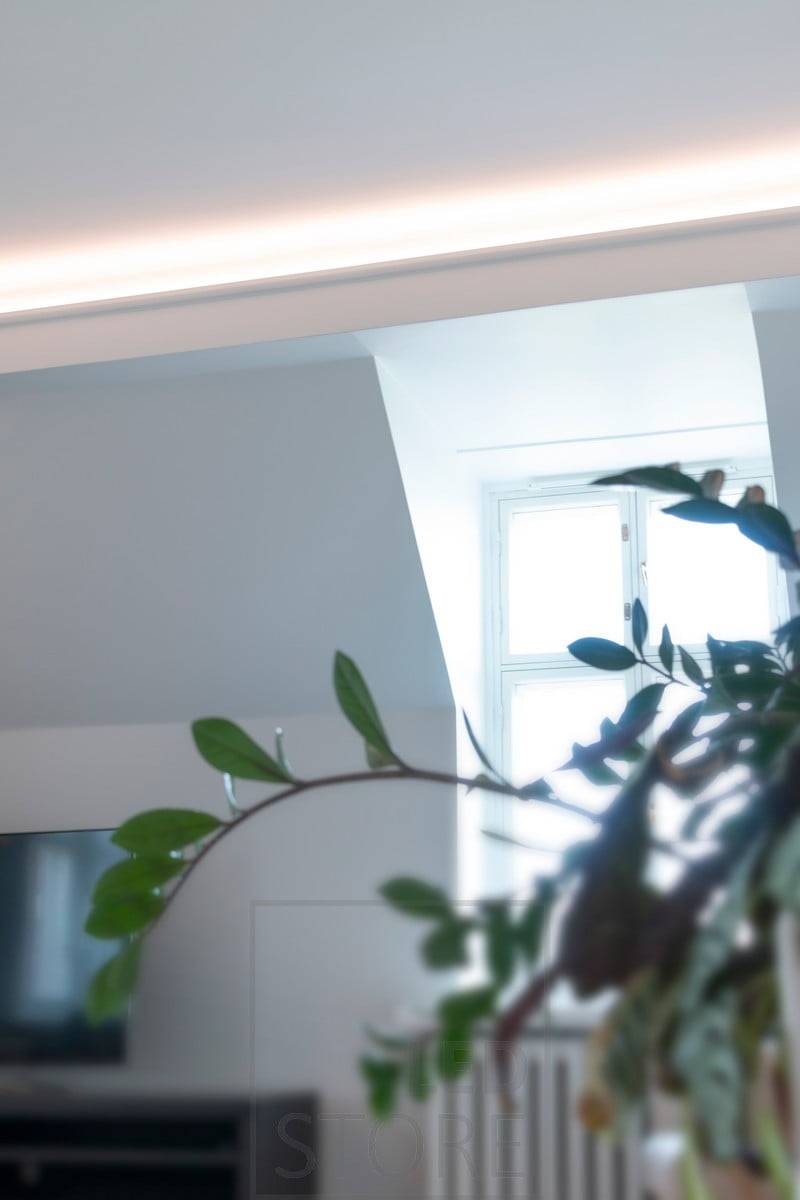 Dans le plafond d'une remise au rez-de-chaussée, une bande LED éclaire indirectement la salle de séjour, orientée vers le plafond et la façade. Ledstore.fi