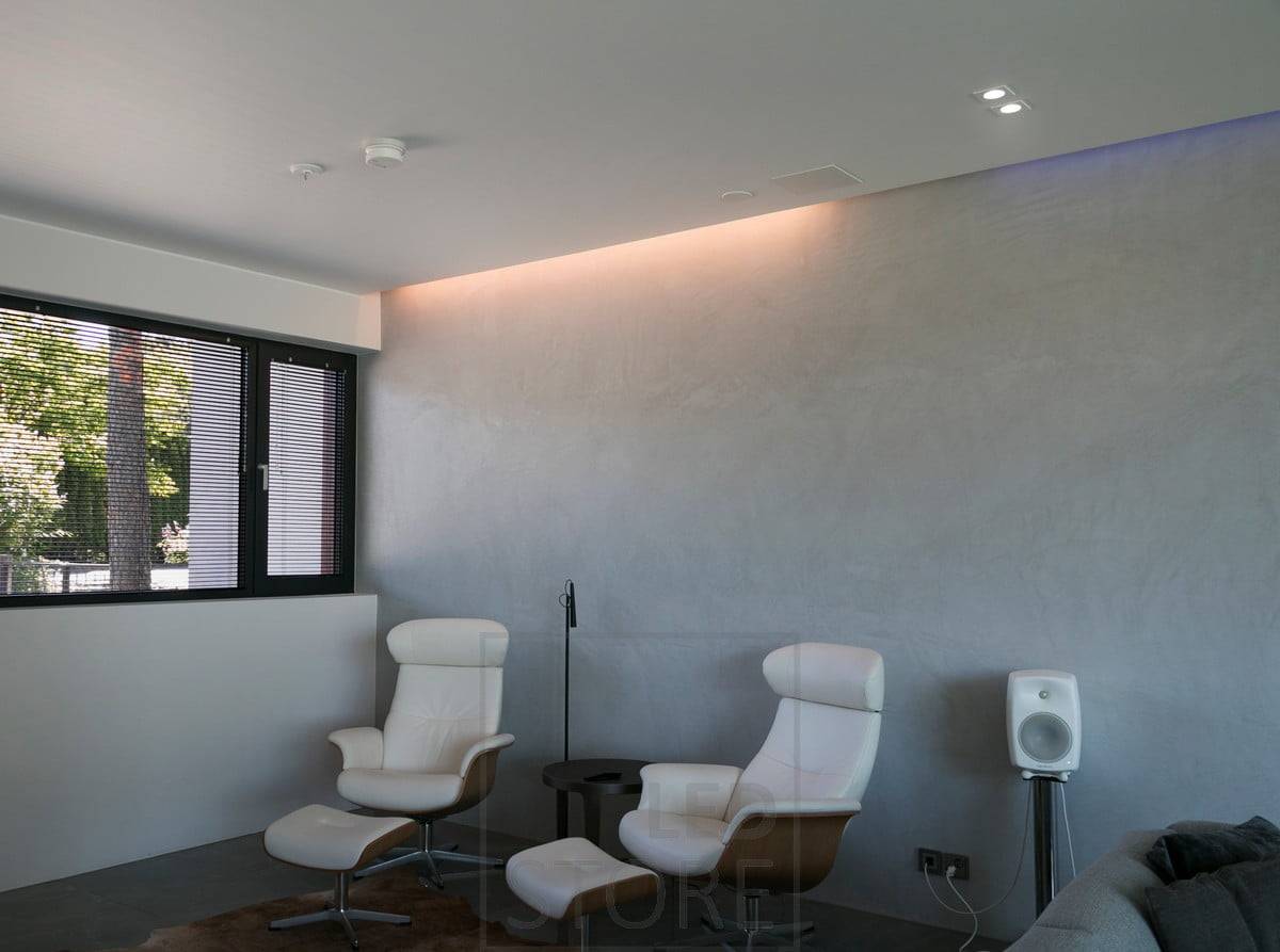 Dans le salon, éclairage indirect entre le plafond et le mur combiné à des spots. Ledstore.fi