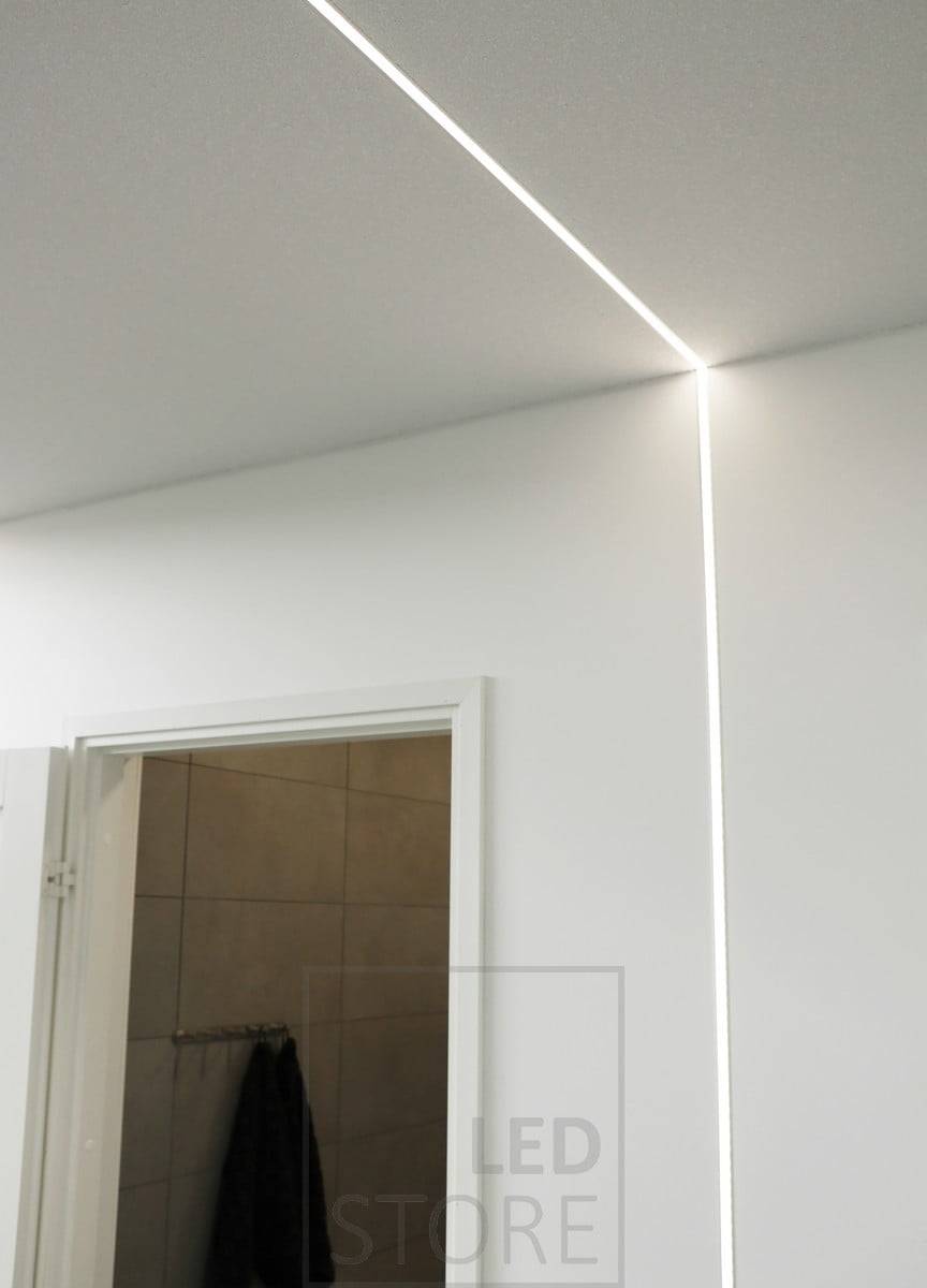 La polyvalence de la bande de diodes électroluminescentes est bien illustrée. La bande LED, montée sur un profilé encastré, s'étend du plafond jusqu'au mur. Ledstore.fi