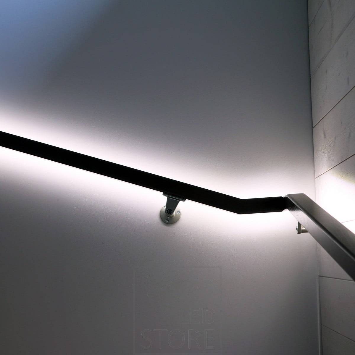 Bande de LED orientée vers le mur sur une main courante, permettant à la lumière d'éclairer le mur avec une lumière indirecte et douce. Ledstore.fi