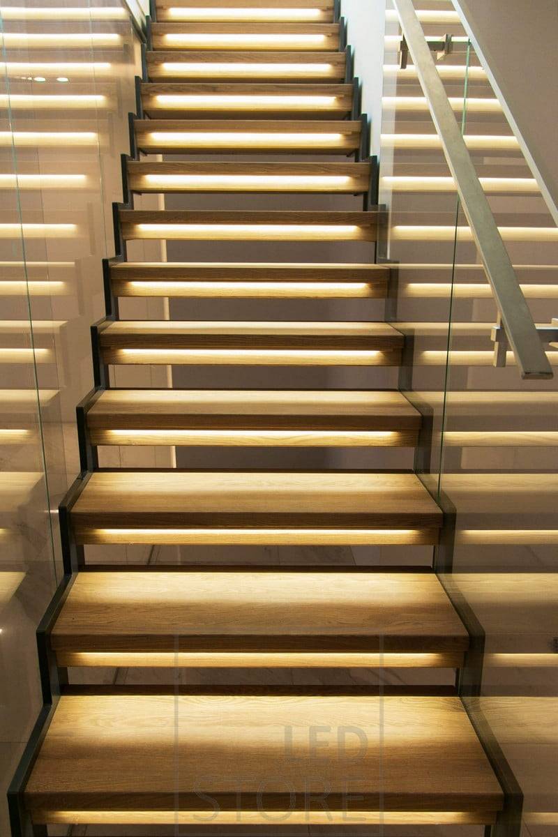 Escalier avec des bandes de leds sur les marches pour éclairer l'escalier de façon atmosphérique. Ledstore.fi