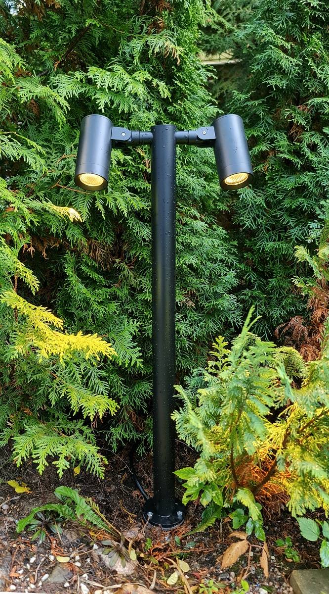 Pilier TILT 2 illuminé dans un jardin extérieur à la lumière du jour.