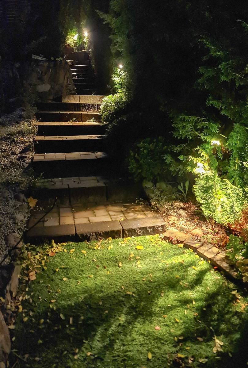 Luminaires TILT 2 installés près des escaliers. Le luminaire est éclairé et c'est le crépuscule à l'extérieur.