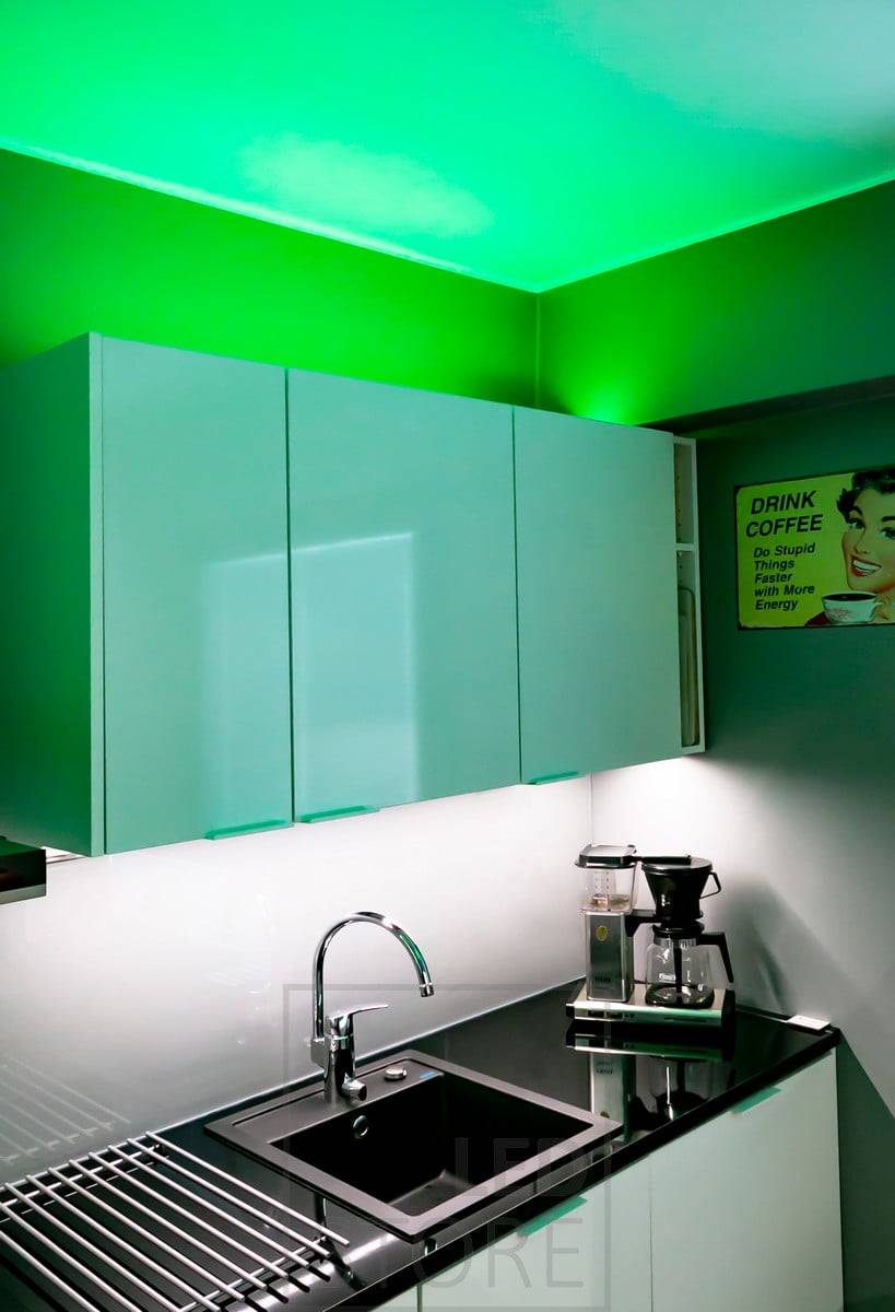 Éclairage d'ambiance polyvalent RGB+W avec bande de LED, créé pour la cuisine, bande de LED dans un profil de surface bas sur le dessus des armoires. La lumière est également disponible en blanc 4000K si l'on souhaite un éclairage d'ambiance plus neutre. Le plan de travail est éclairé par une bande de LED monochrome. Ledstore.fi