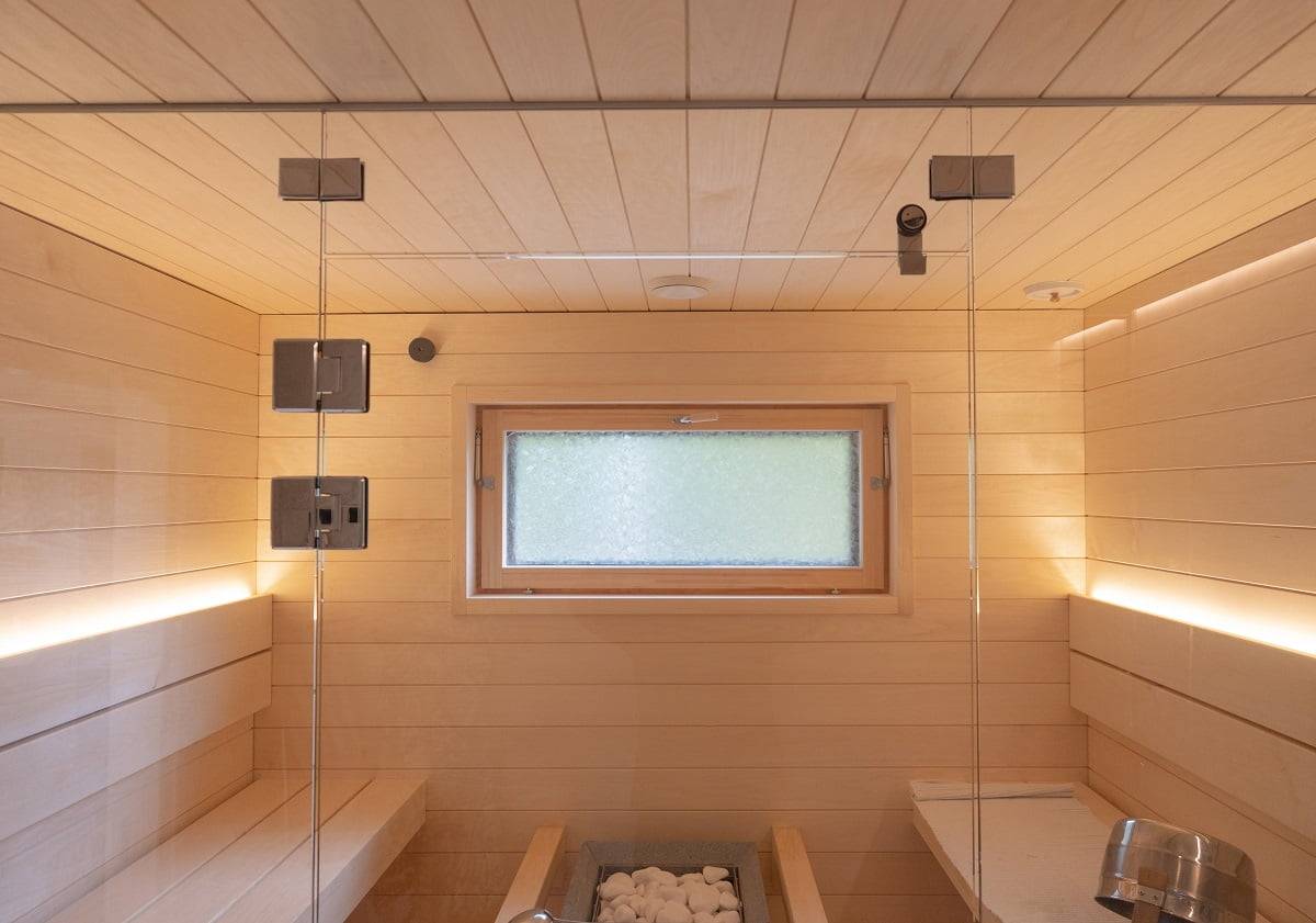Sauna avec bande LED sur le dossier éclairant vers le haut. Deux bandes LED suffisent à l'éclairage du sauna lorsque la lumière peut s'ouvrir.