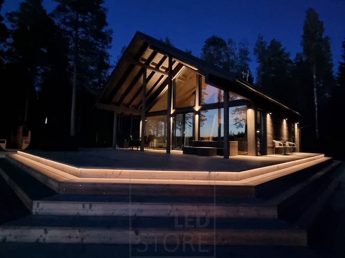 Éclairage extérieur polyvalent avec une bande LED sur l'escalier et des appliques murales. Les appliques murales éclairent dans deux directions en hauteur et dans une direction en contrebas. Ledstore.fi