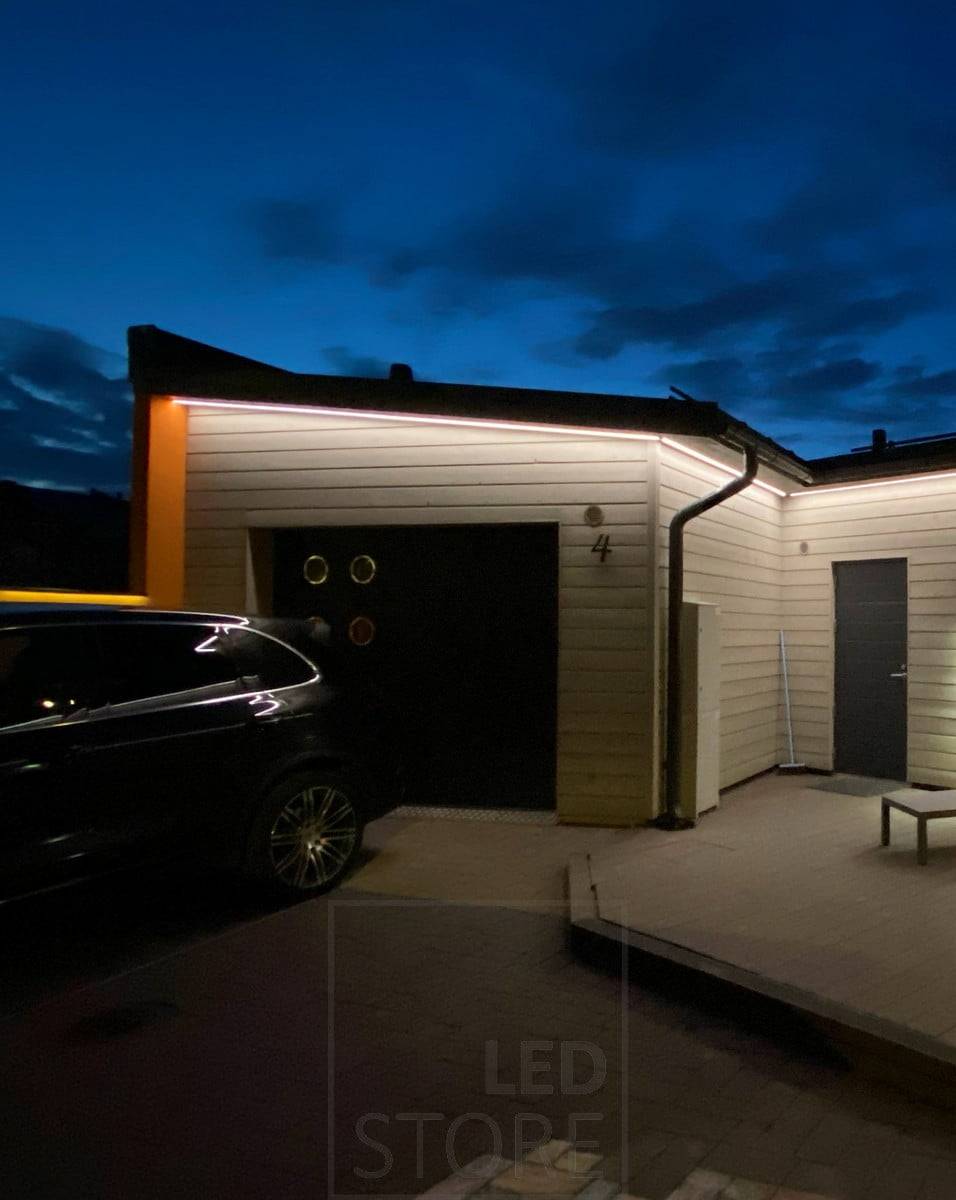 Ruban de leds sur l'avant-toit éclairant la façade et la cour d'une maison. Ledstore.fi