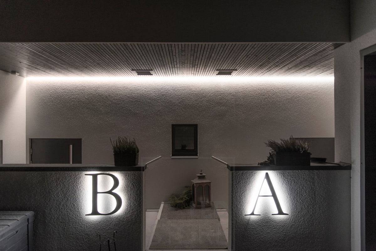 Eclairage extérieur avec lumière indirecte. Bande LED derrière les lettres des maisons. Ledstore.fi