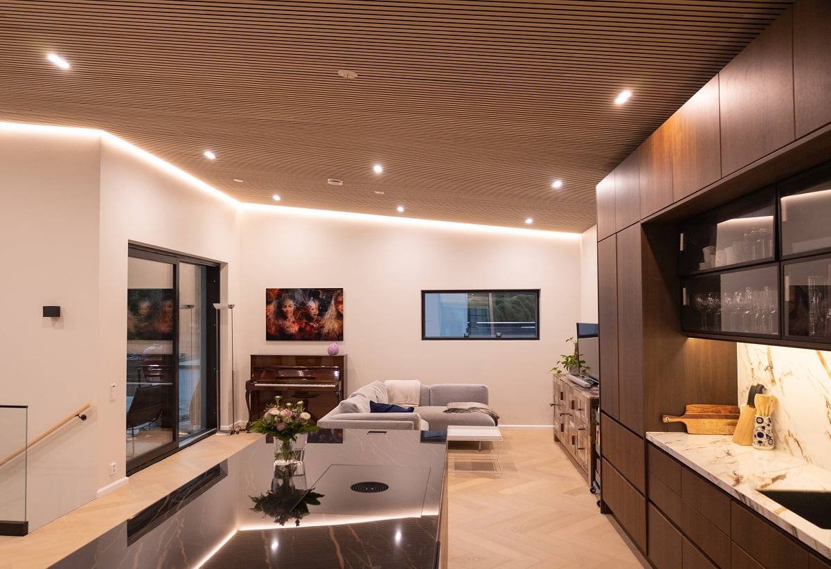 Le salon, la cuisine et la salle à manger sont éclairés par des luminaires Kantti doubles et une bande LED de 14,4 W/m montée indirectement. ledStore.fi