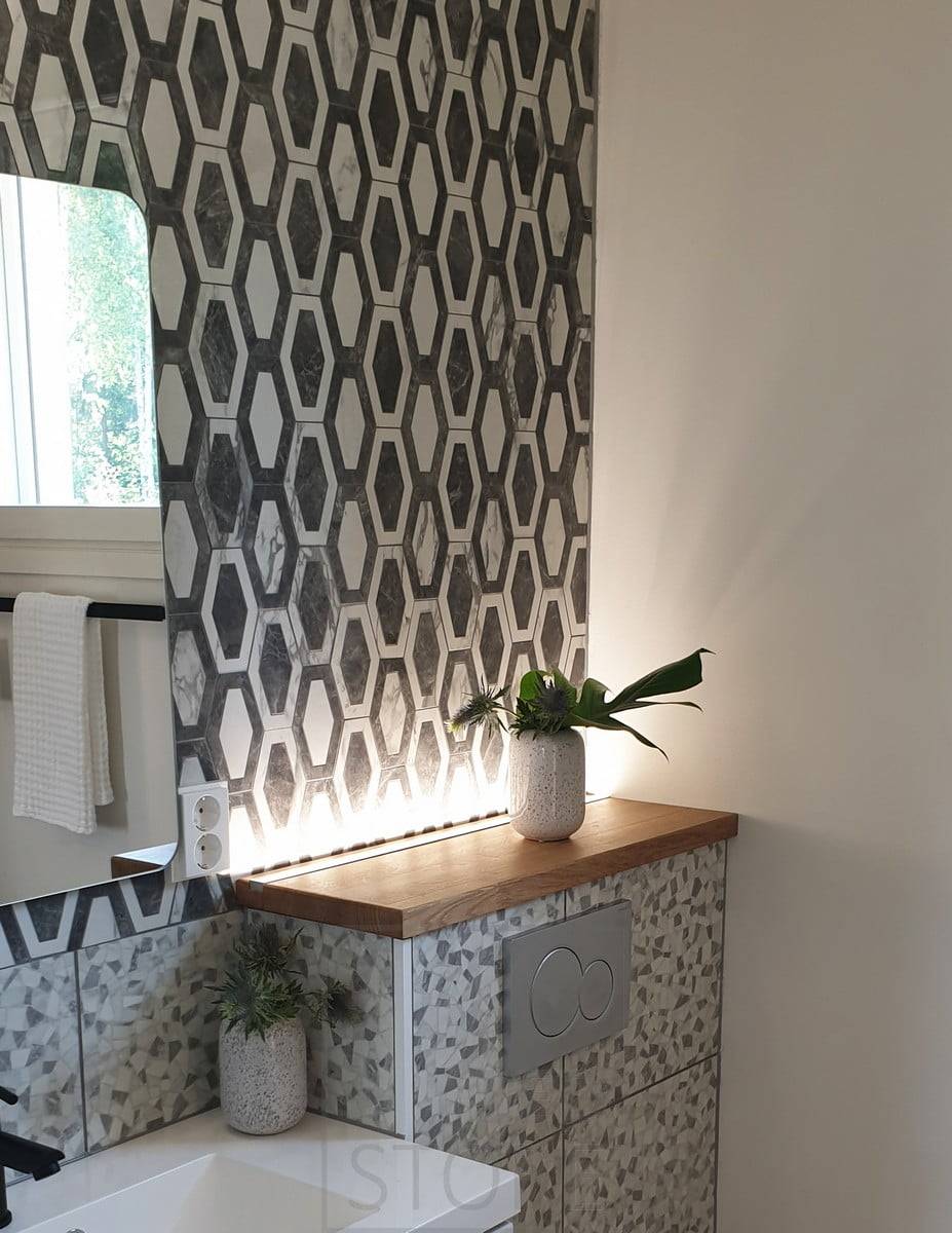 Bande LED derrière le boîtier des toilettes, orientée vers le haut, créant une lumière d'ambiance agréable. Ledstore.fi