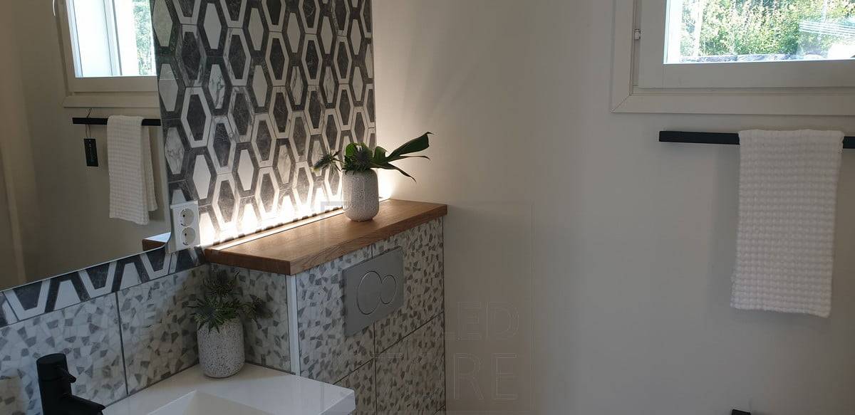 Bande LED derrière le boîtier des toilettes, orientée vers le haut, créant une belle lumière d'ambiance, fonctionnant également comme veilleuse. Ledstore.fi