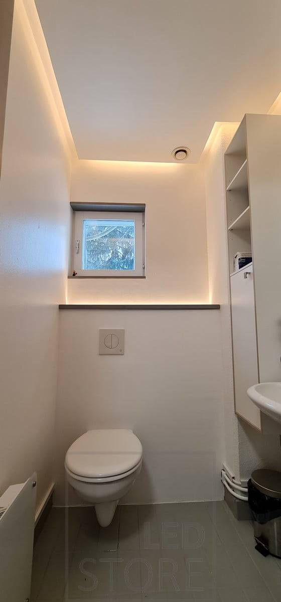 Éclairage indirect pour l'ensemble de la salle de bains. La bande LED sur le boîtier des toilettes fait également office de veilleuse et s'allume grâce à un détecteur de mouvement. Ledstore.fi