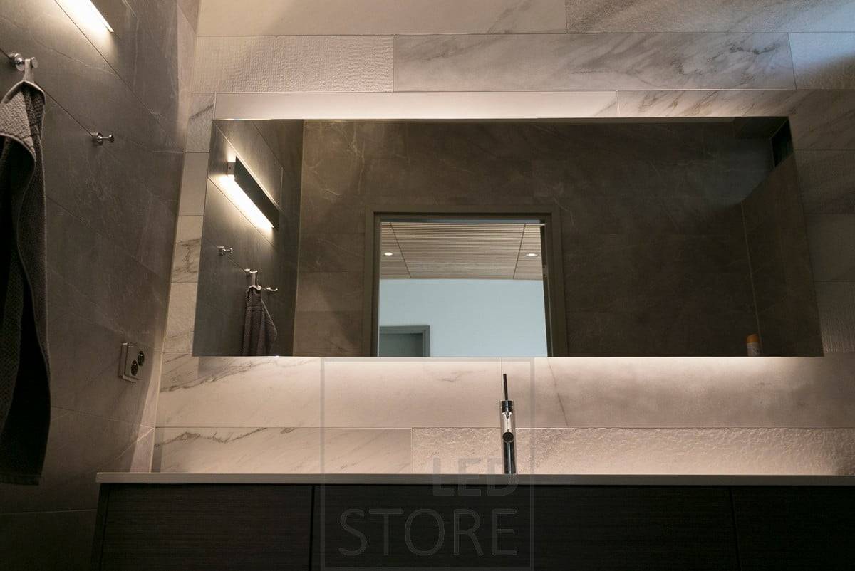 Derrière un beau et grand miroir, une bande LED met en valeur le miroir et crée un éclairage d'ambiance. En outre, une applique murale bidirectionnelle. Ledstore.fi