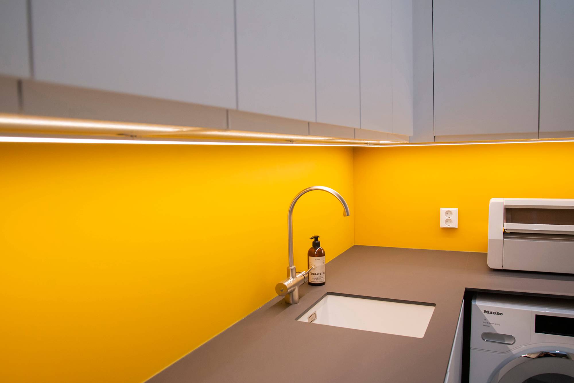 Lumière apportée dans les niveaux de la buanderie avec des bandes de LED, montées sur un profilé de surface. Ledstore.fi