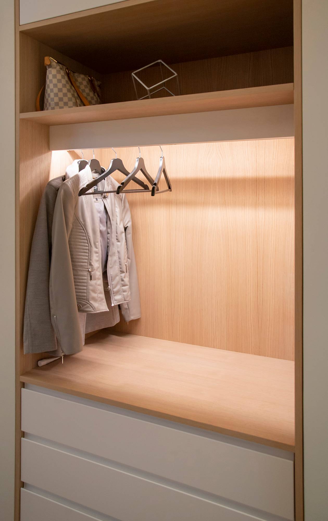 Une armoire avec une bande lumineuse à LED qui éclaire le contenu de l\'armoire avec une lumière indirecte. Ledstore.fi