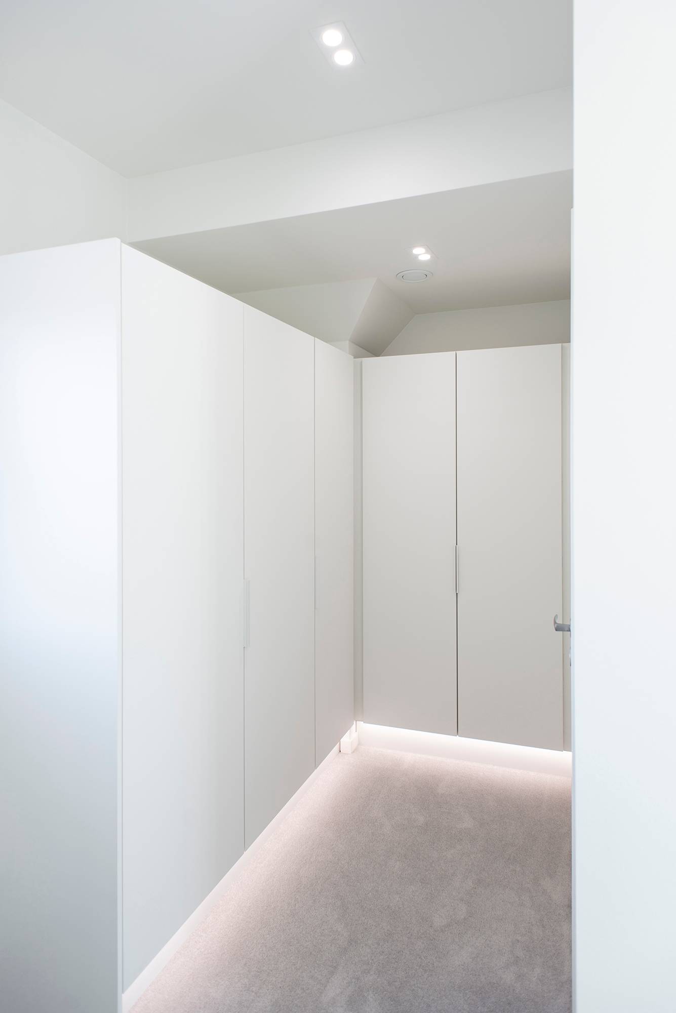 Bande LED en profilé d\'aluminium sur le socle éclairant la lumière indirecte, downlights TUPLA KANTTI au plafond. Ledstore.fi