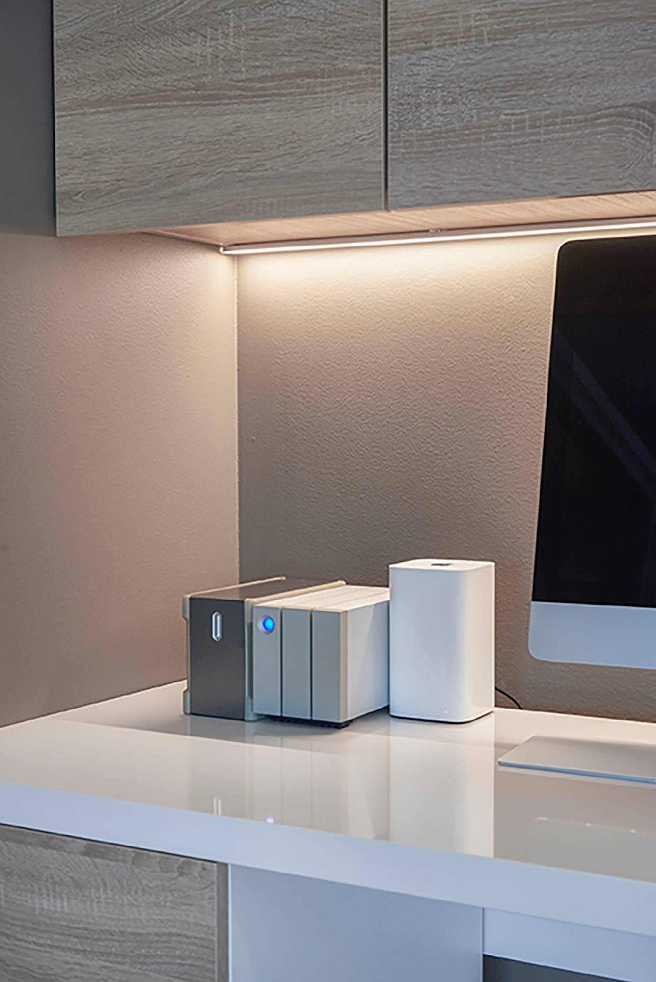 Mur indirectement éclairé derrière un poste de travail avec une bande LED. La lumière est atmosphérique et agréable à l\'œil. Ledstore.fi