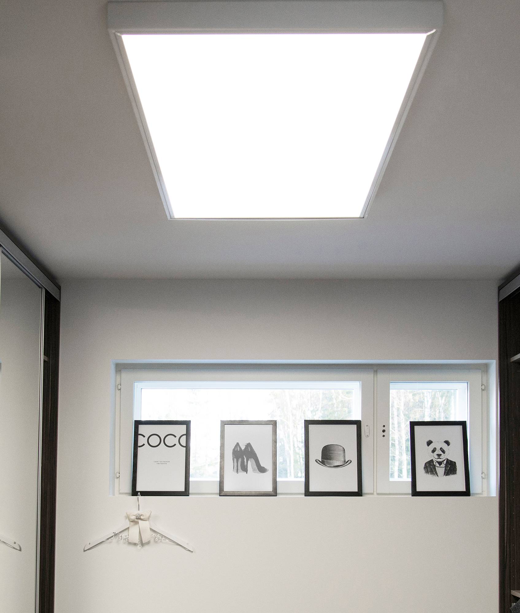 panneau de 600x1200 au plafond d\'un couloir dans un cadre de surface. Le grand luminaire ressemble à un puits de lumière et éclaire l\'espace de manière uniforme et efficace. Ledstore.fi