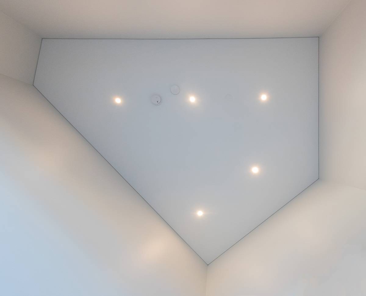 Spots LED au plafond, vus directement d'en bas. La disposition des spots peut être adaptée à la forme de l'espace, comme dans cet espace à cinq arêtes.