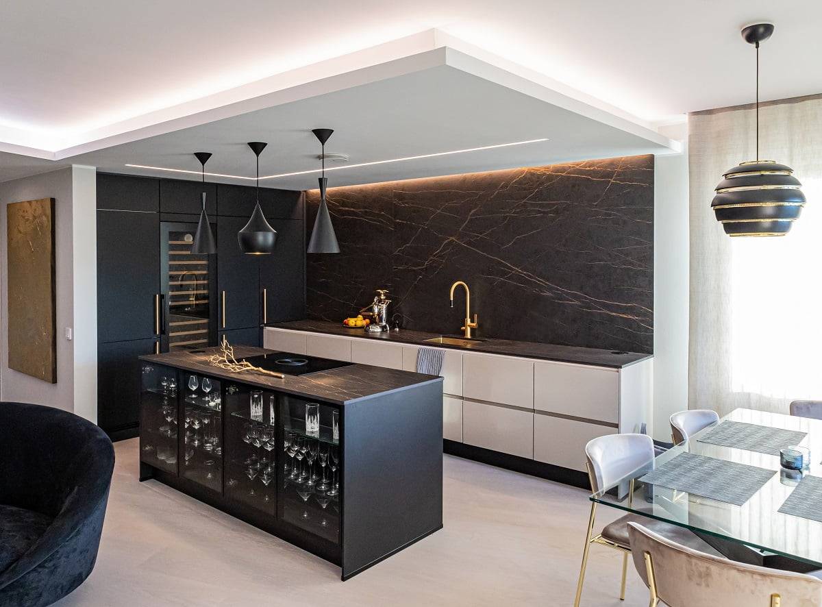 Des bandes lumineuses à diodes électroluminescentes enveloppent les bords du plafond abaissé de la cuisine.