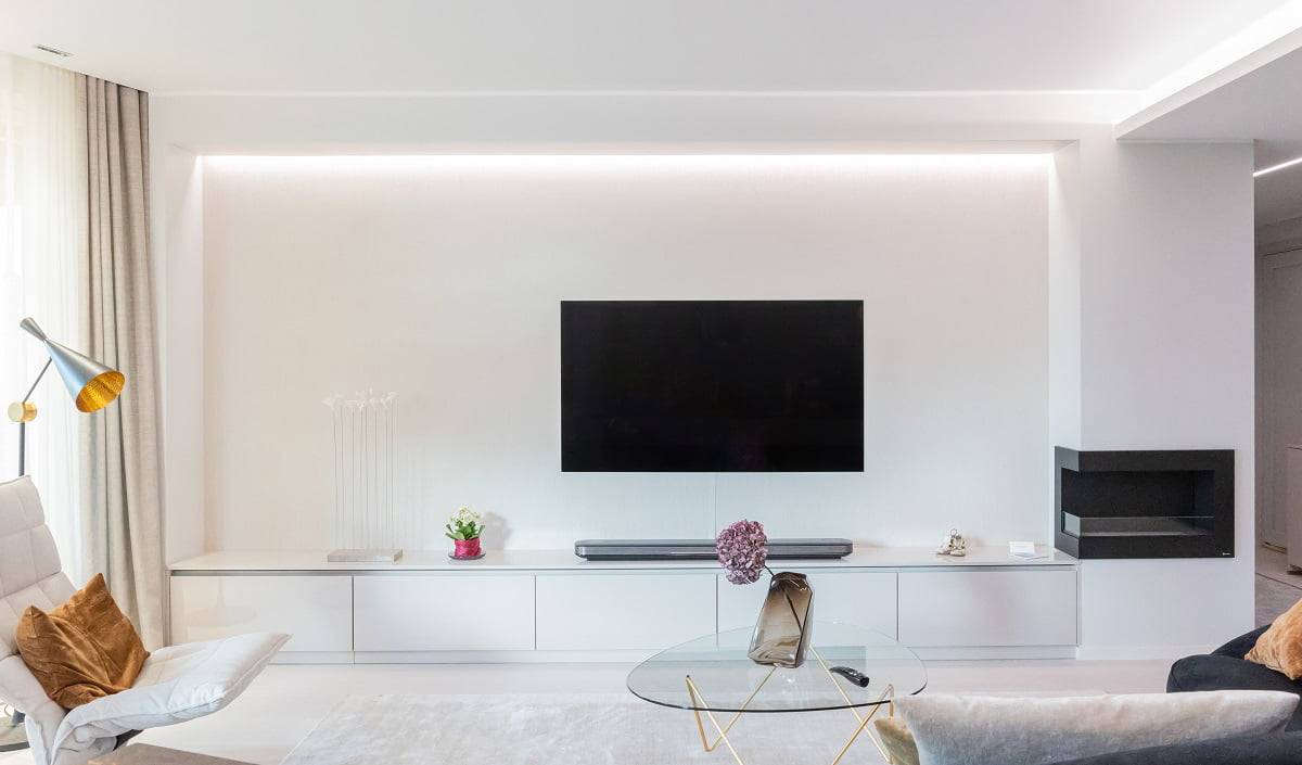 La puissance de la bande LED est adaptée à cette destination. Un éclairage agréable à l'œil derrière un mur de télévision avec une bande LED indirecte dans la rainure du plafond.
