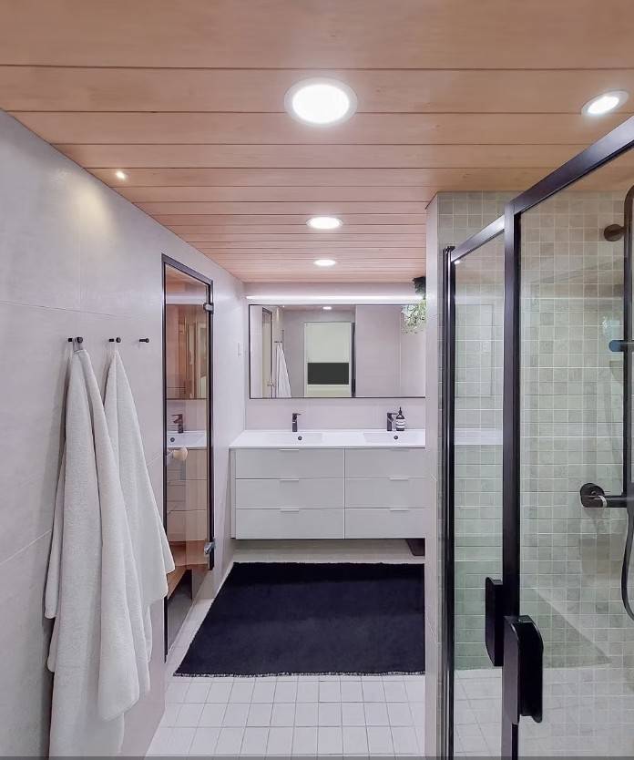 Éclairage de la salle de bains avec des panneaux lumineux, des spots, des rails LED devant le miroir et des spots étanches au plafond.