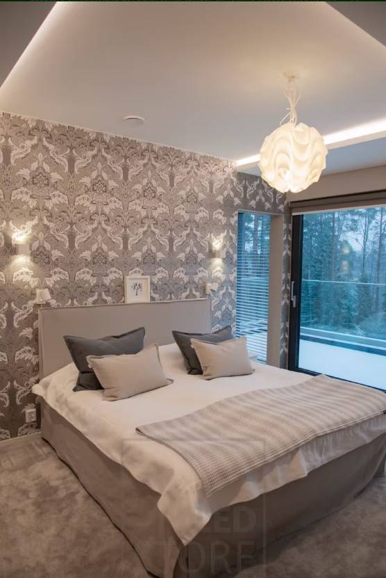 Dans cette chambre à coucher, des appliques XL-Cubic ont été installées sur le mur et une bande LED dans le poteau d'éclairage pour ajouter de l'ambiance. Le plafonnier ajoute une touche décorative et plus de lumière à la pièce. 