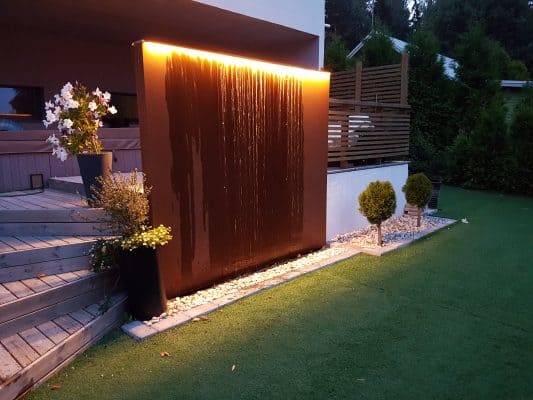 Un jeu d'eau moderne pour le jardin, avec une bande LED au sommet qui s'illumine vers le bas.