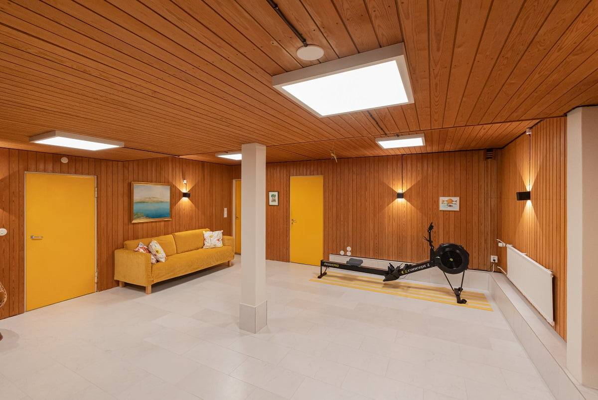 Un bon éclairage favorise l'exercice physique. Panel 600 est réglable en température de couleur, du blanc froid au blanc chaud. Sur le mur Funk, appliques murales noires. LedStore.fi  