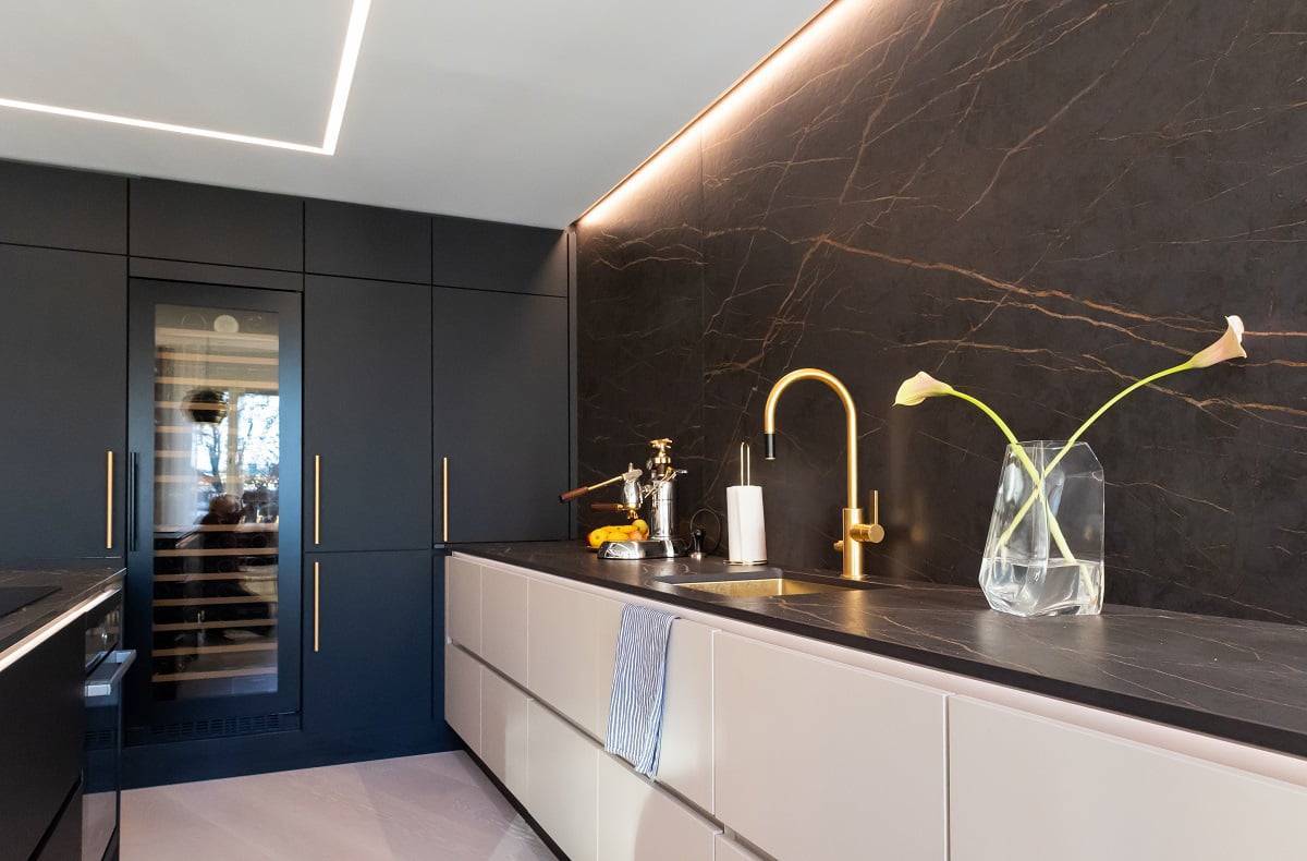 Dans la zone de travail de la cuisine, il y a un spot plat au plafond et une bande lumineuse LED vers le mur comme lumière d'accentuation. LedStore