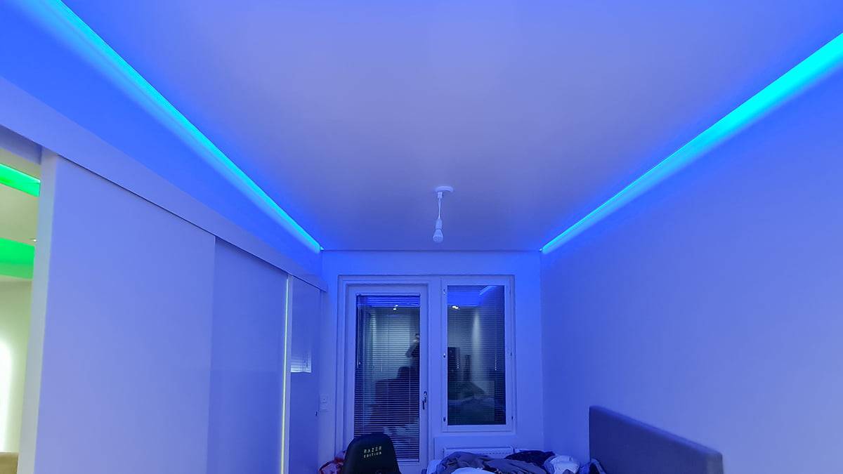 Lumière indirecte au plafond. Un moment bleu dans le plafond bas d'une chambre à coucher.