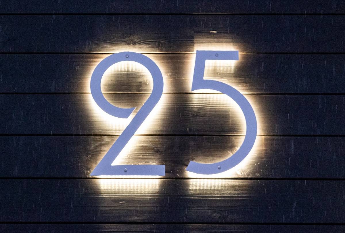 Numéro de maison éclairé par des diodes électroluminescentes sur un mur sombre