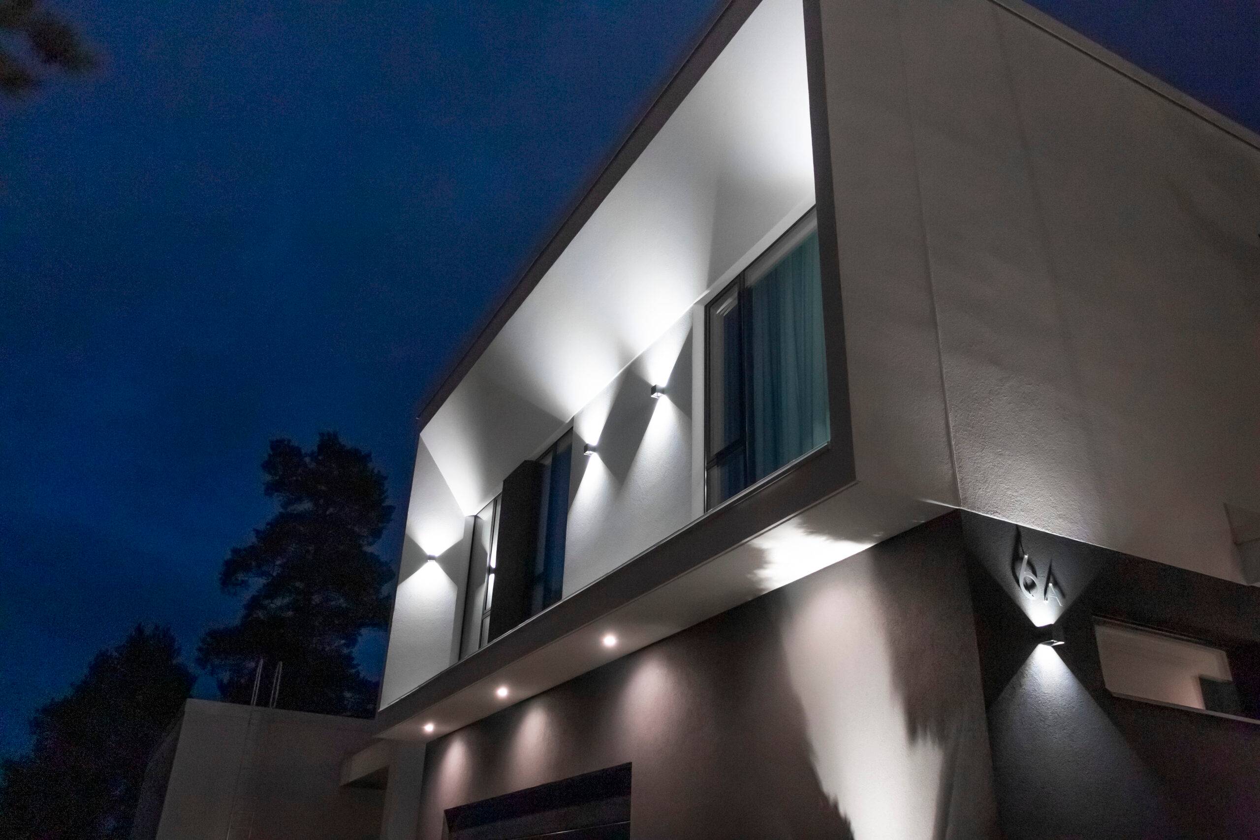 L'éclairage de cour à LED est créé par des appliques murales et des projecteurs à LED orientés vers le bas. En outre, une applique murale éclaire le numéro de la maison. 