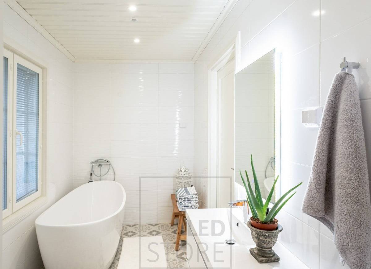 Au plafond, la salle de bains dispose d'un éclairage général avec des spots et un miroir pour soutenir l'éclairage.  