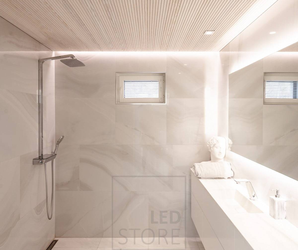 La salle de bain dispose d'un éclairage polyvalent et atmosphérique. HALO 1200 comme miroir lumineux et des spots CHEAP KANTTI au niveau du sol pour éclairer le visage par le haut. Bande LED installée dans la rainure entre le plafond et le mur pour éclairer l'espace avec une lumière d'ambiance indirecte à travers le mur. Ledstore.fi  