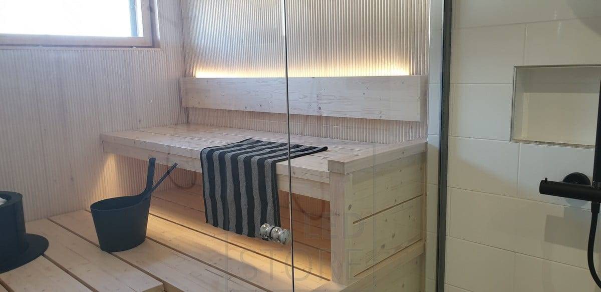 La bande LED située à l'arrière du dossier du sauna éclaire la lumière lunatique vers le haut et vers le bas, sous le plafond. Ledstore.fi