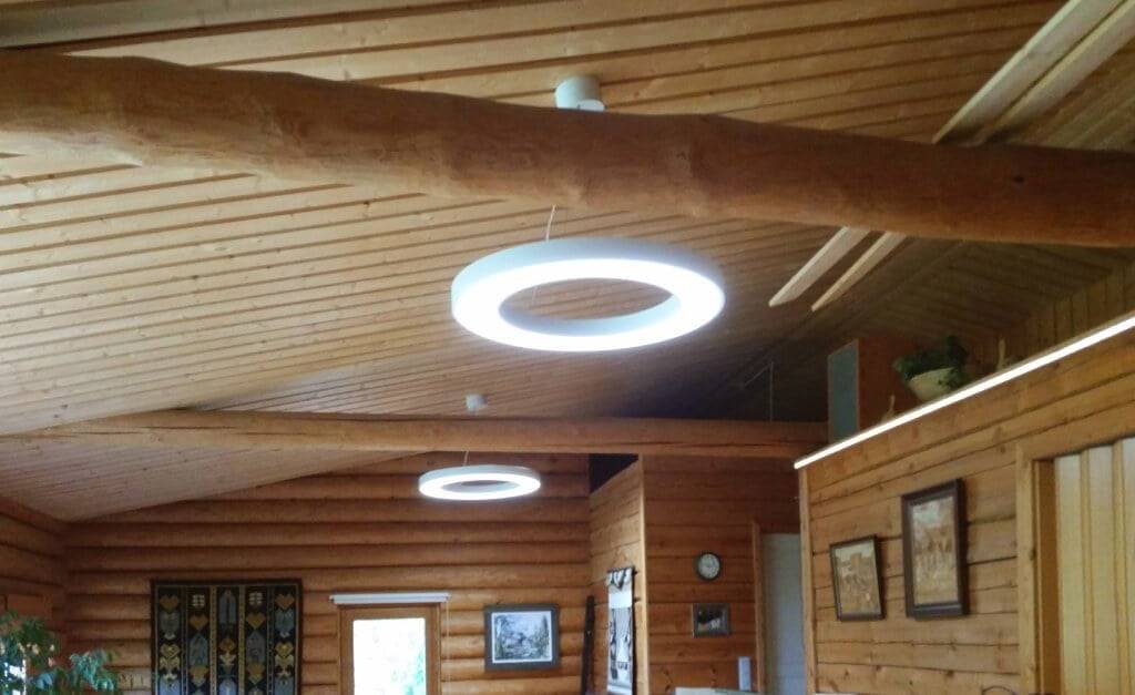 Sur quoi se fondent les affirmations selon lesquelles les lampes LED sont dangereuses ? Les murs et le plafond en rondins créent un charme rustique avec des œuvres d'art encadrées, une horloge et des tapisseries.