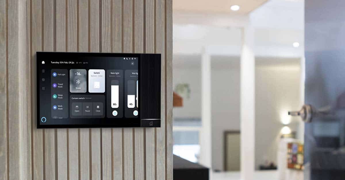 Sur le mur beige d'une maison moderne se trouve un panneau de commande intelligent de LedStore.fi pour contrôler l'éclairage LED et le home cinéma.