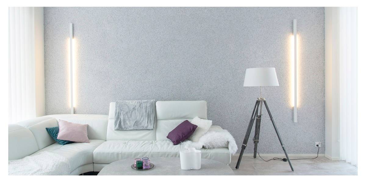 La conception de l'éclairage d'un salon est importante, dans l'image un salon harmonieux avec des appliques sur le mur du fond.