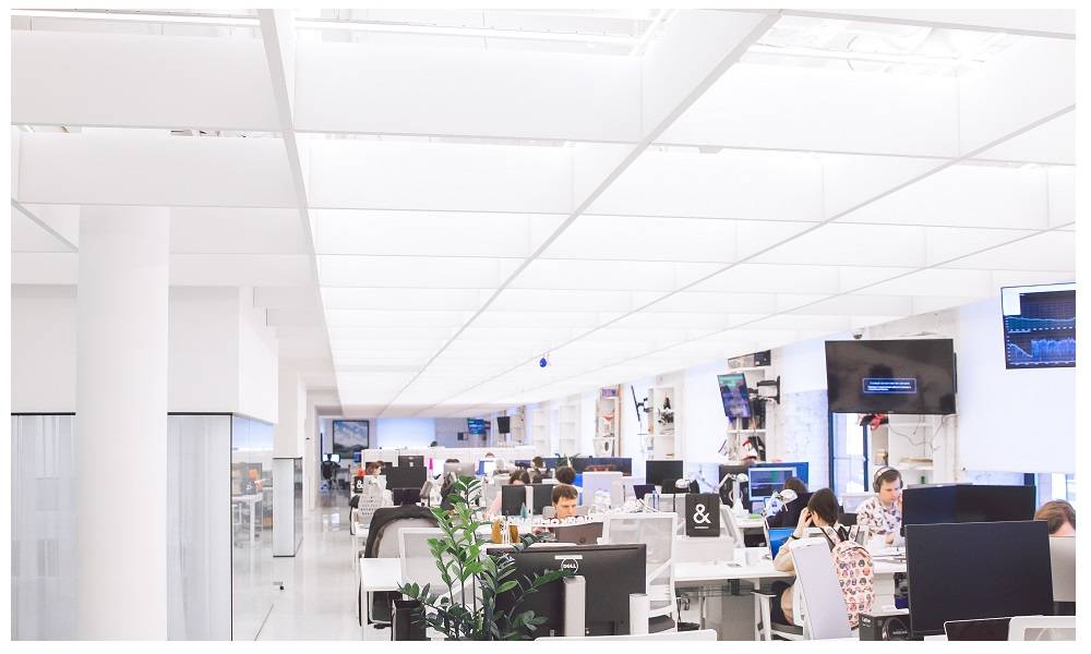 Bureau ouvert avec des surfaces claires et lumineuses et de nombreux postes de travail.