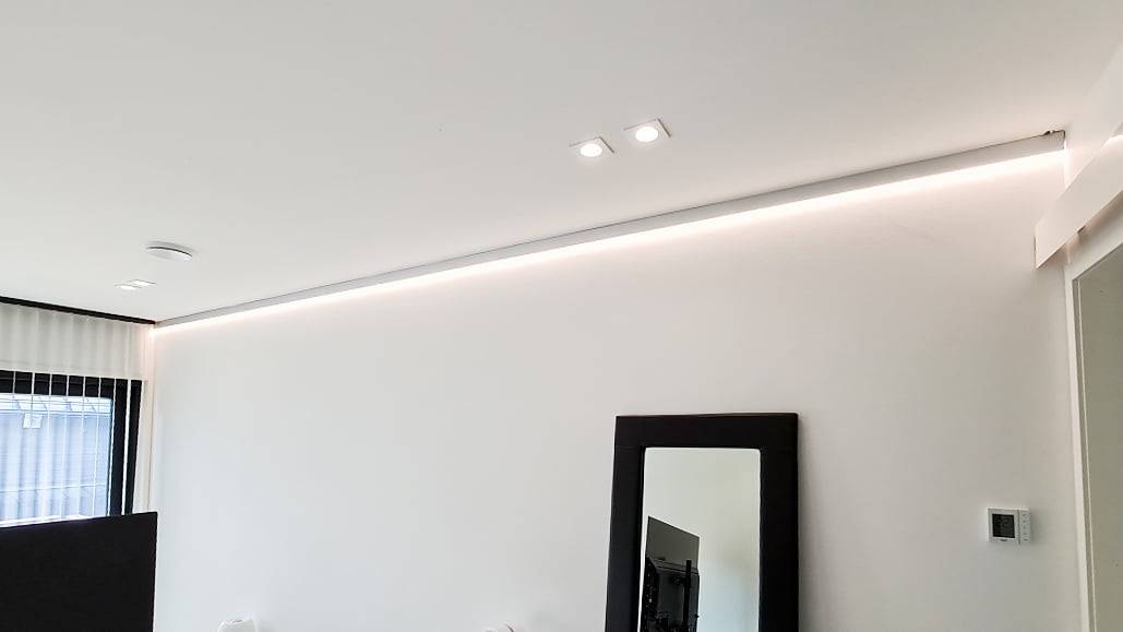 Lumière indirecte installée dans le plafond de la chambre et spots pour l'éclairage général.